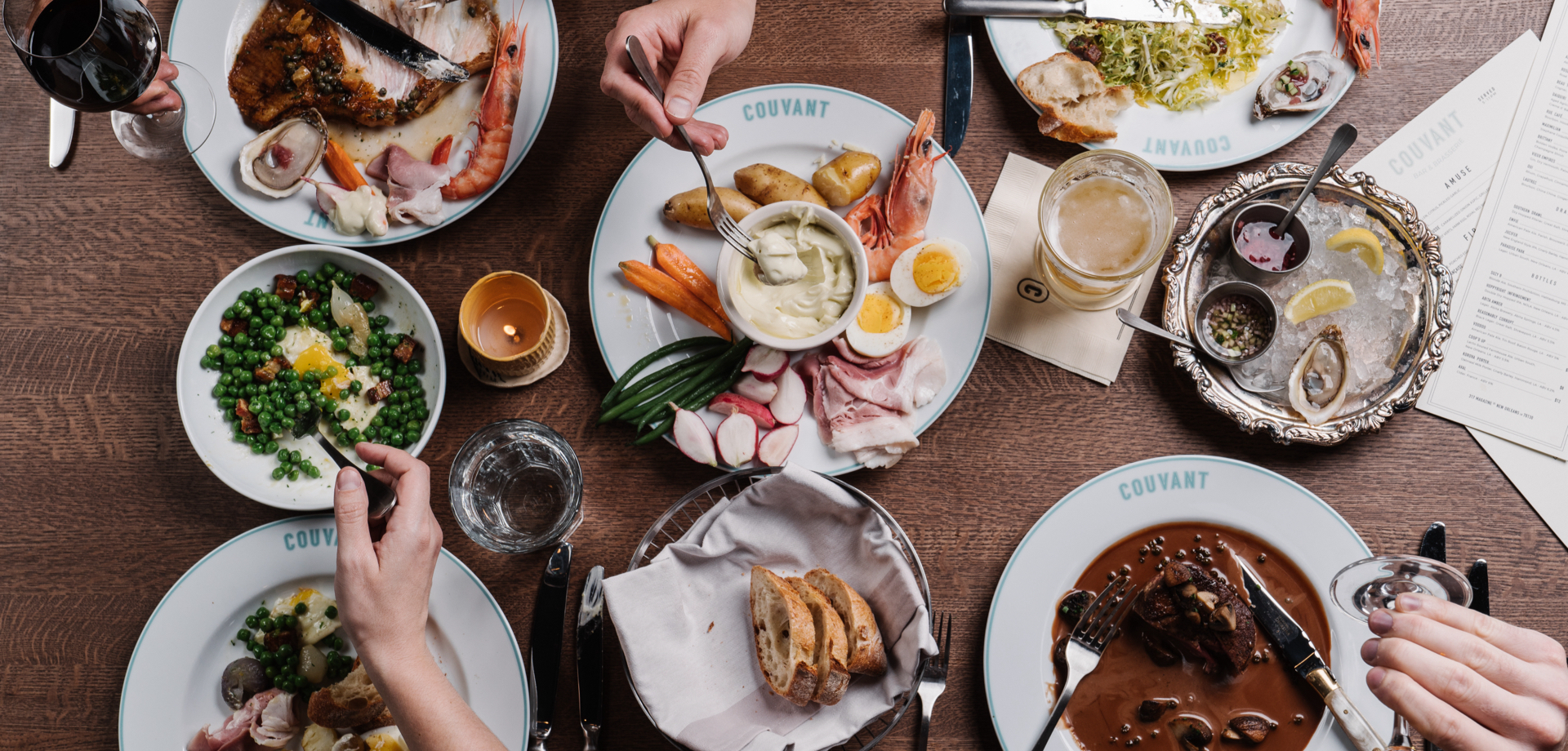Birds Eye view of plates of food with people using forks