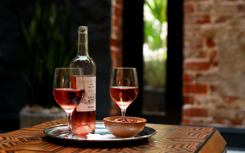 Bottle of rose with two full wine glasses
