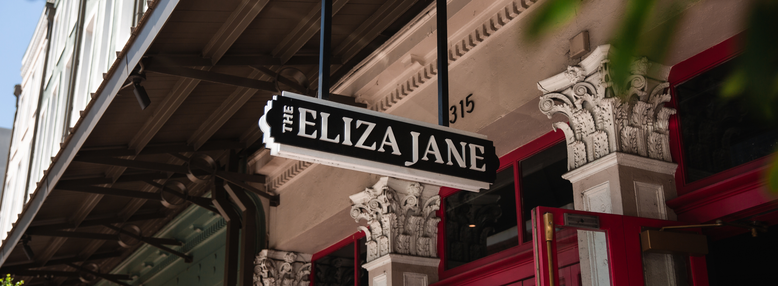 sign hanging from building that says The Eliza Jane