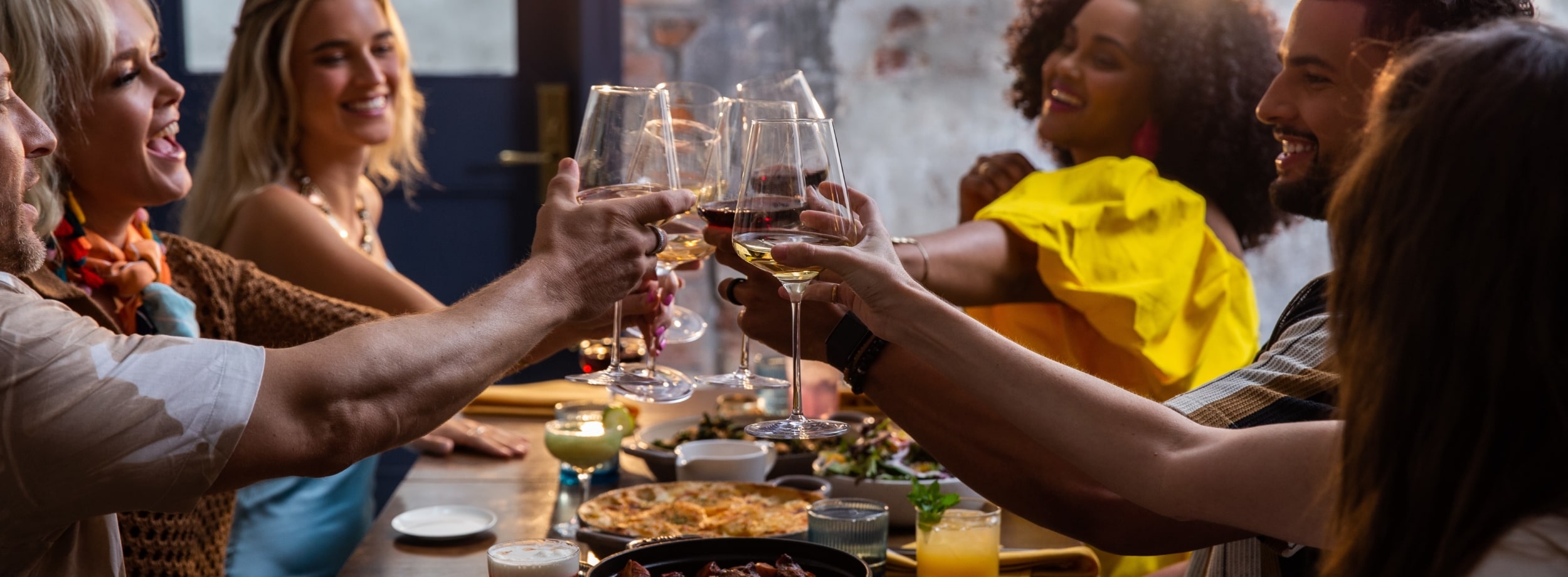 friends toasting at a dinner table