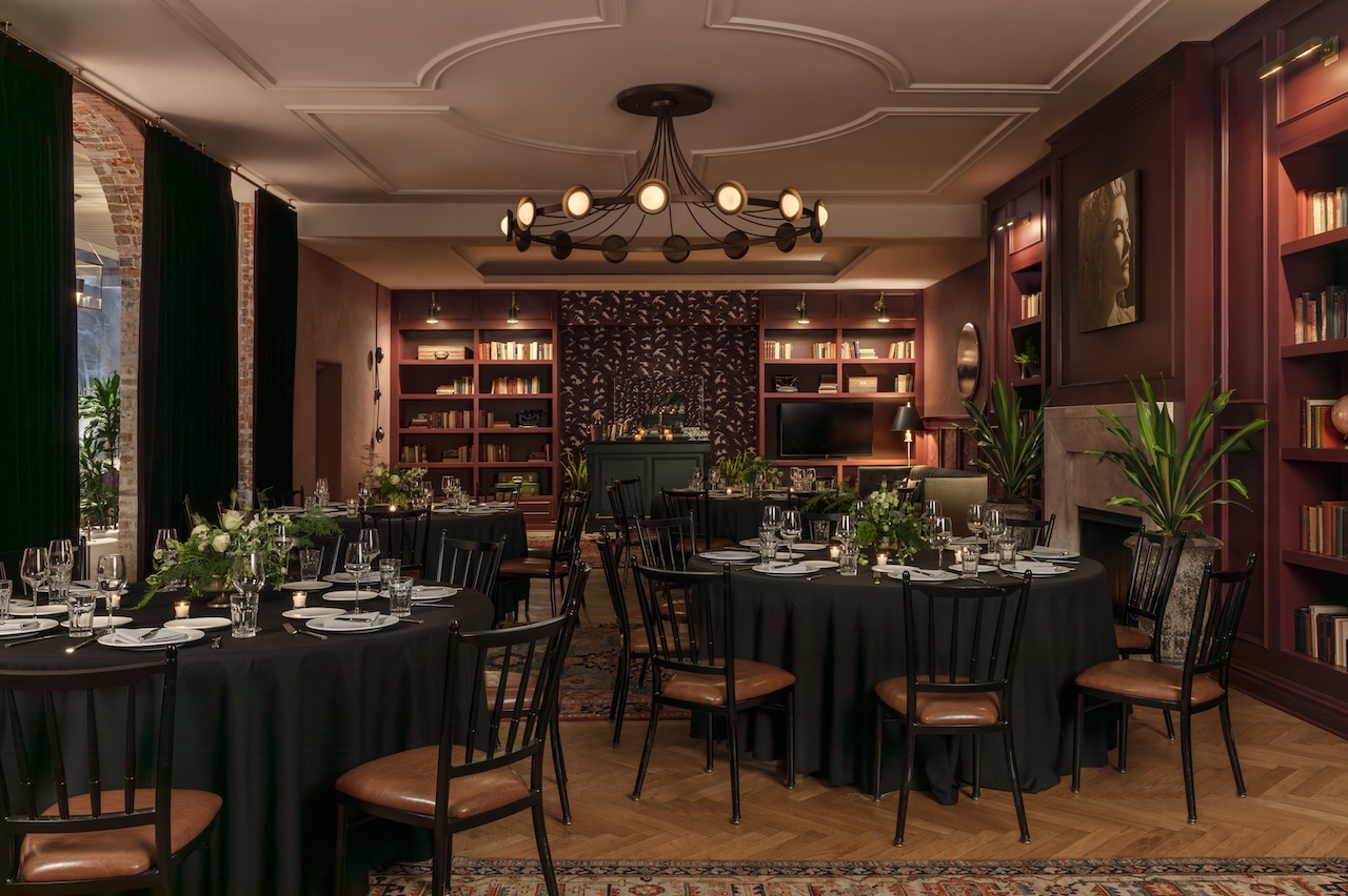 Round dinner tables set for a reception and dinner in a cozy library