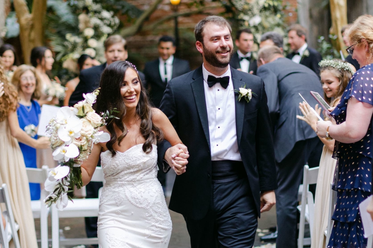 bride and groom walking down the aisle after ceremony with smiles on guests faces